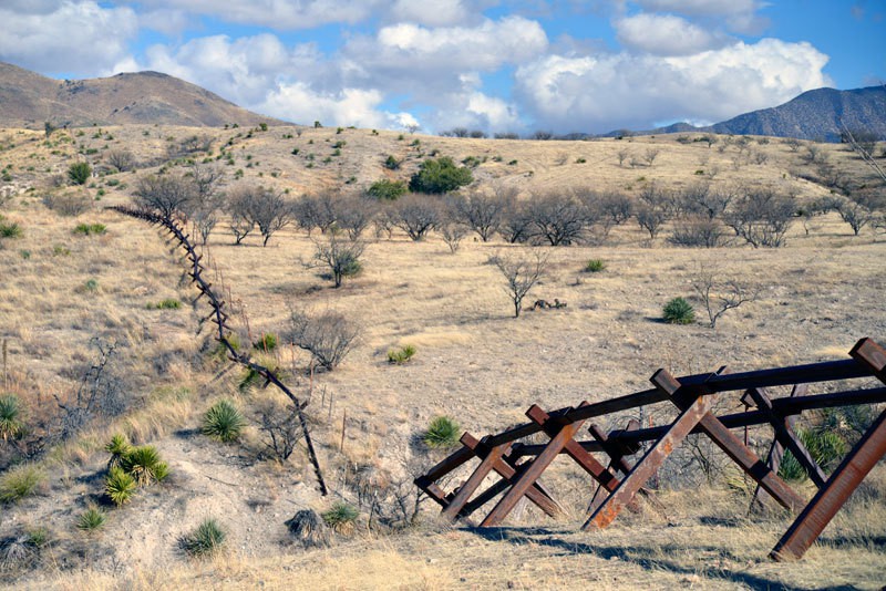 Barriers like these east of Nogales, Ariz., are all that separate the United States from Mexico along large sections of the border. Photo by Lillian Reid.