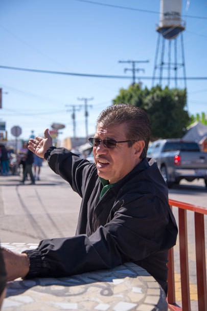 Mayor Enrique Navarro sits outside a pharmacy in downtown Los Algodones, Mexico. He said the businesses in his town provide quality health care and medicines for customers from across the border. Photo by Lillian Reid.