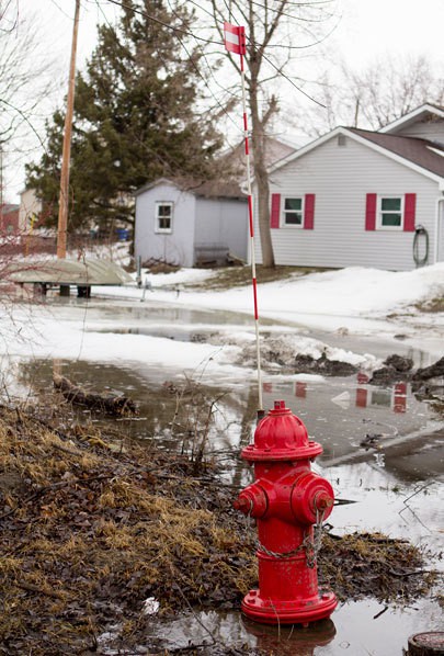 A flag atop a fire hydrant marks the U.S.-Canadian border within the Akwesasne Territory. There are no border fences or checkpoints within this part of the territory. Photo by Alex Lancial.