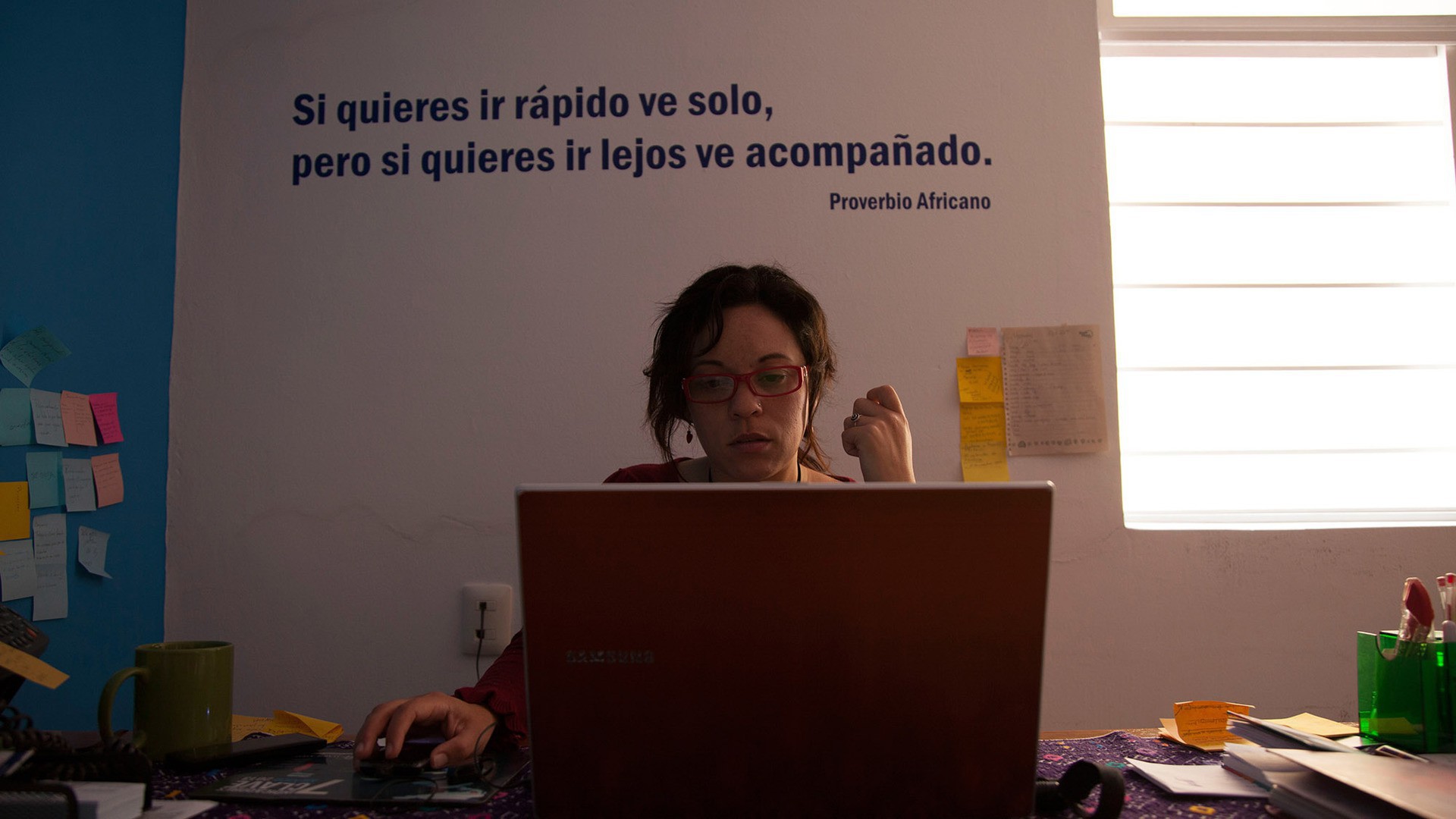 Geicel Yamileth Benitez Fuentes sits at her desk in the Marie Stopes Clinic in San Cristóbal de las Casas. The phrase above her reads, 'If you want to go quickly go alone, but if you want to go far go accompanied.; (Photo by Rachel Leingang.)