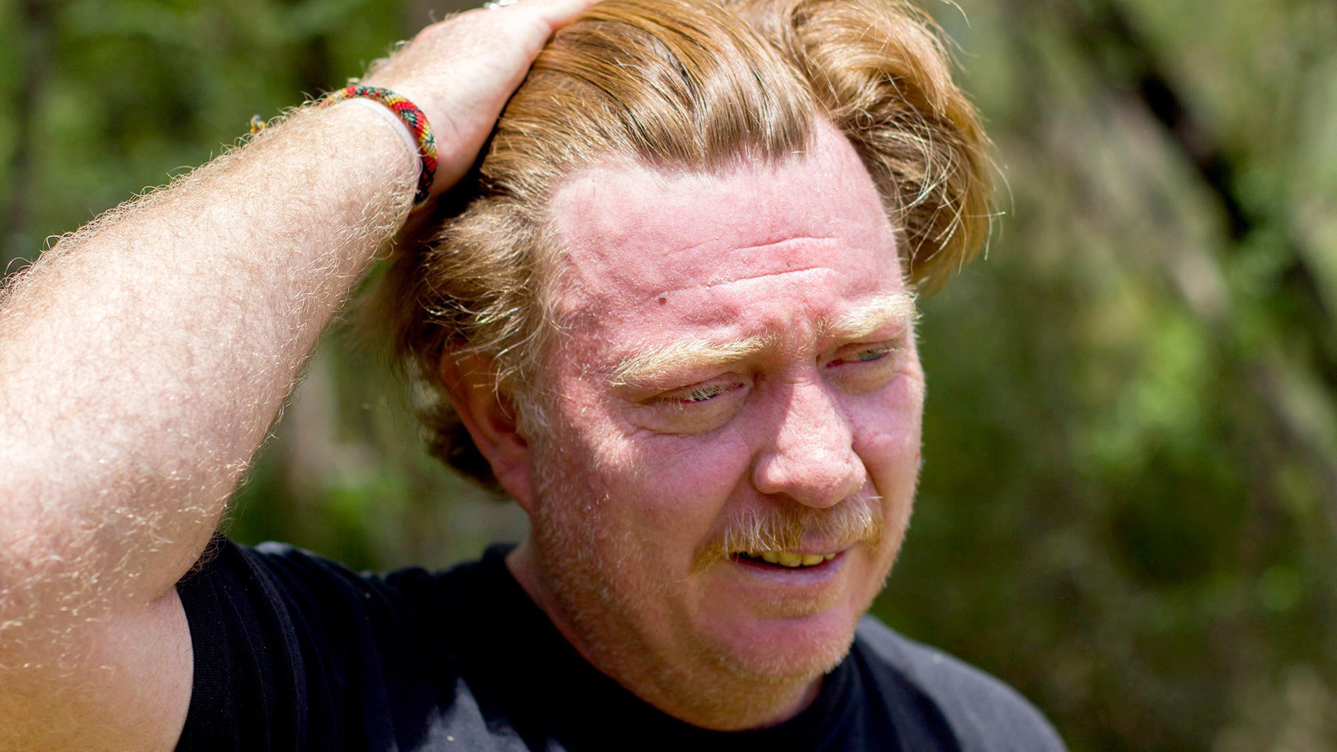 Virgil Edwards pushes his hair back after spending a few hours pruning trees. His eyes are red from sawdust that fell in them. (Photo by Connor Radnovich.)