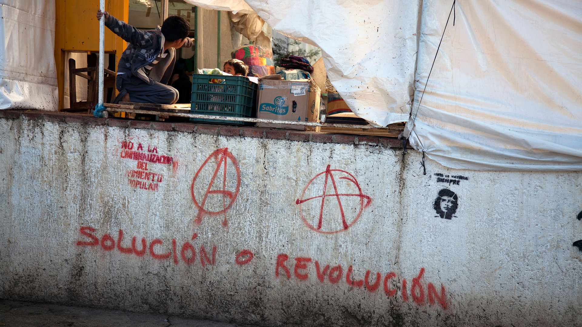 Children play at a market in San Cristóbal de las Casas, where the Zapatistas staged an armed revolution 20 years ago. Grafitti sprayed onto the city's walls shows the contemporary influence of the leftist movement. (Photo by Rachel Leingang.)