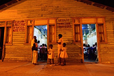 People wait by the door of Open Arms, a Haitian protestant church, in Comendador, Dominican Republic.