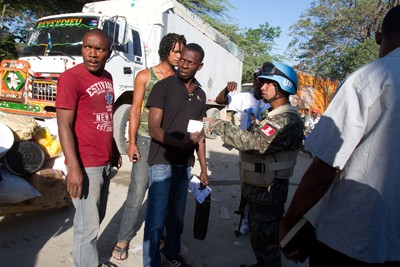 A United Nations soldier checks the papers of Haitians crossing into the Dominican Republic to trade in the local bi-national  market in Comendador.