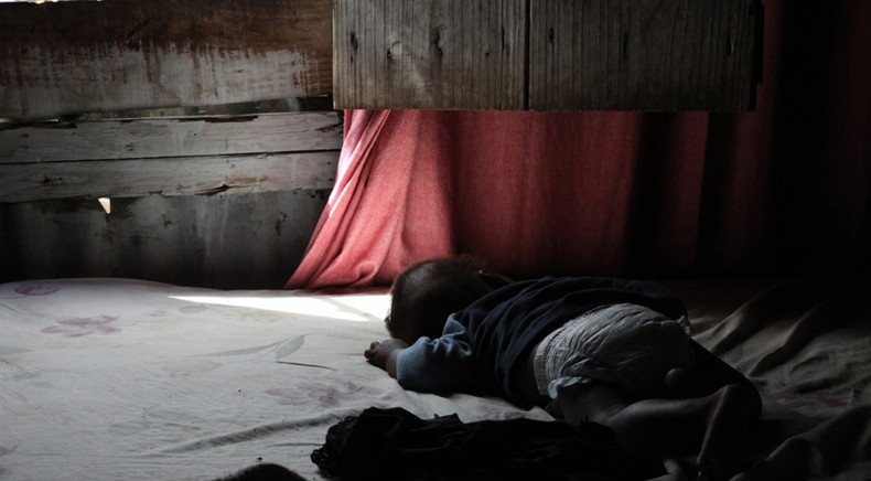 Abraham Axicinean, 5 months old, takes a nap at the home of Eriana Alce in Batey San Isidro. His mother was only 17 when she died giving birth to him.