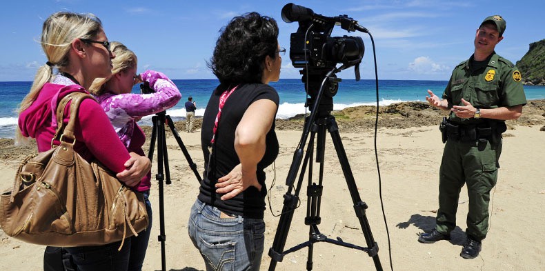 Supervisory Border Patrol Agent Edgardo Milan, right, is interviewed by a group of Cronkite students while touring common migrant landing areas on the west coast of Puerto Rico. The students, from left,  Danielle Bergrigghe, McKenzie Manning and Gardenia Coleman, traveled to the coastal community of Aguadilla to report on migrants crossing the open ocean from the Dominican Republic. Photo by Brandon Quester