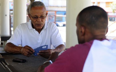 Arcadio 'Chino' Drullard, 71, plays cards with another Dominican Republic national in Plaza Barcelo, a small park in Barrio Obrero. Drullard now lives with his brother and one son after leaving his wife and 11 children behind in the Dominican Republic. Photo by Brandon Quester