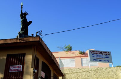 A miniature Statue of Liberty juts into the skyline in Barrio Obrero, a heavily Dominican neighborhood in Santurce, Puerto Rico. The building is owned by José Lora-Gerónimo, a consultant on immigration and residency applications. He offers consultations free of charge. Photo by Brandon Quester