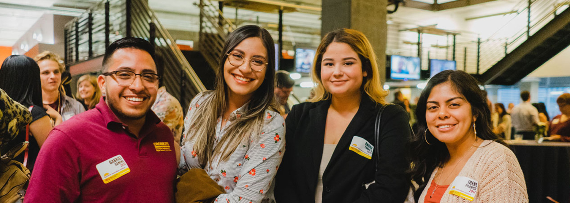 Four alumni pose for a picture at an alumni event.