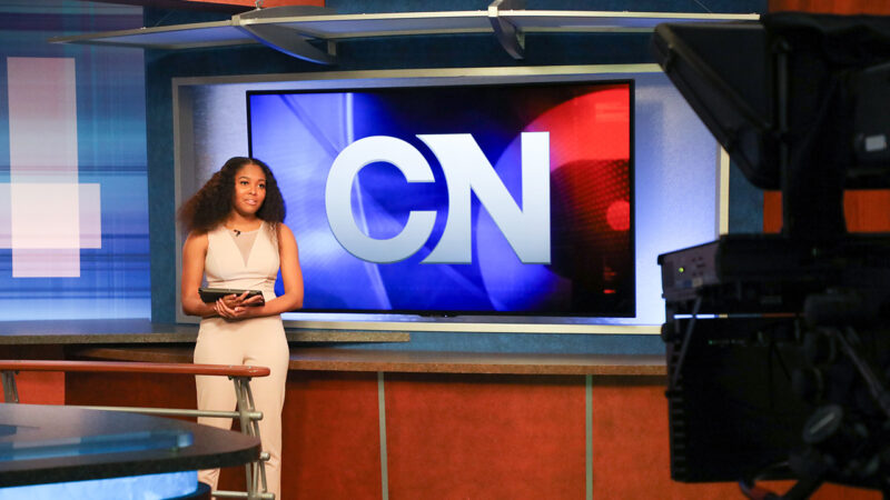 A student delivers a newscast in front of cameras in Cronkite News.