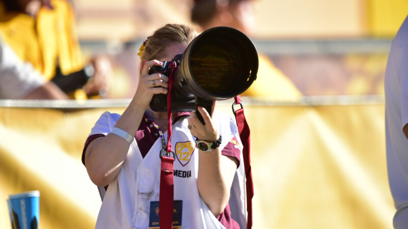 A student photographs a sporting event.