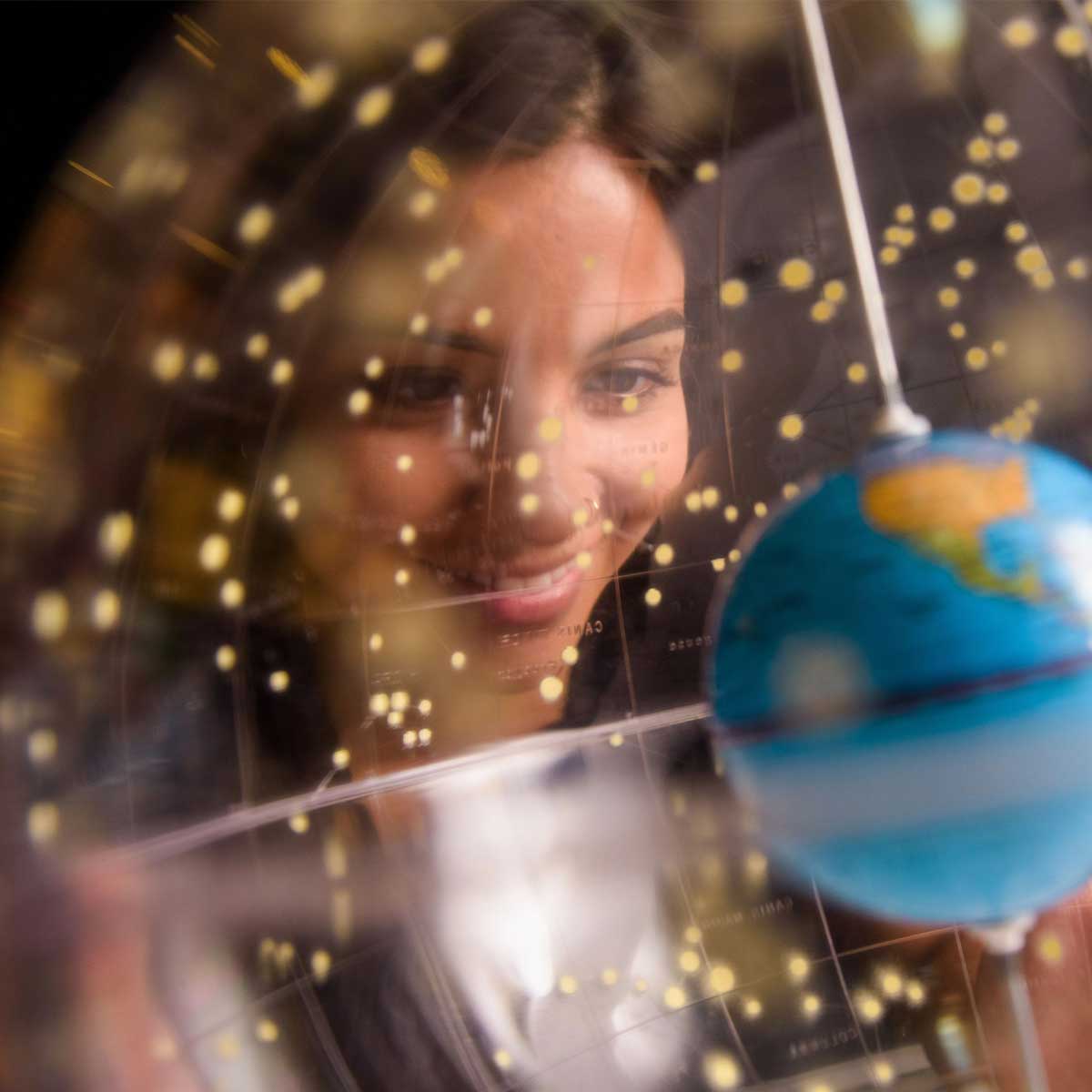 Stylized image of a smiling woman looking at a globe