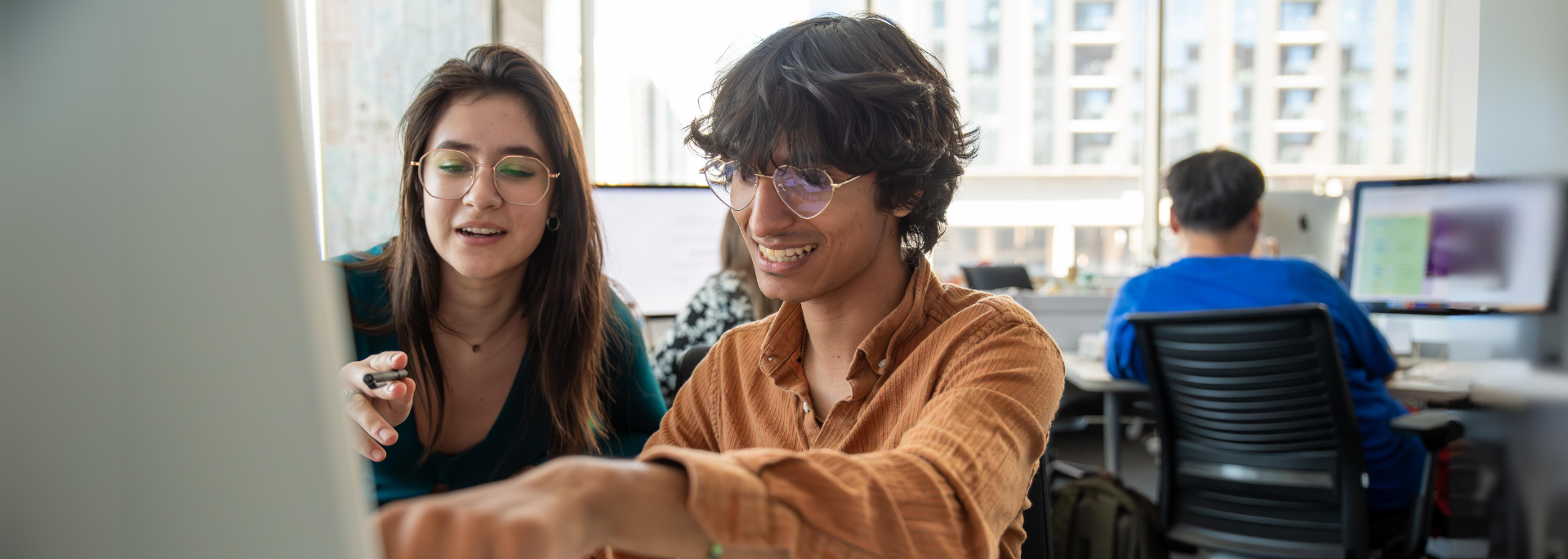 Two students in the Howard Center collaborate at a computer